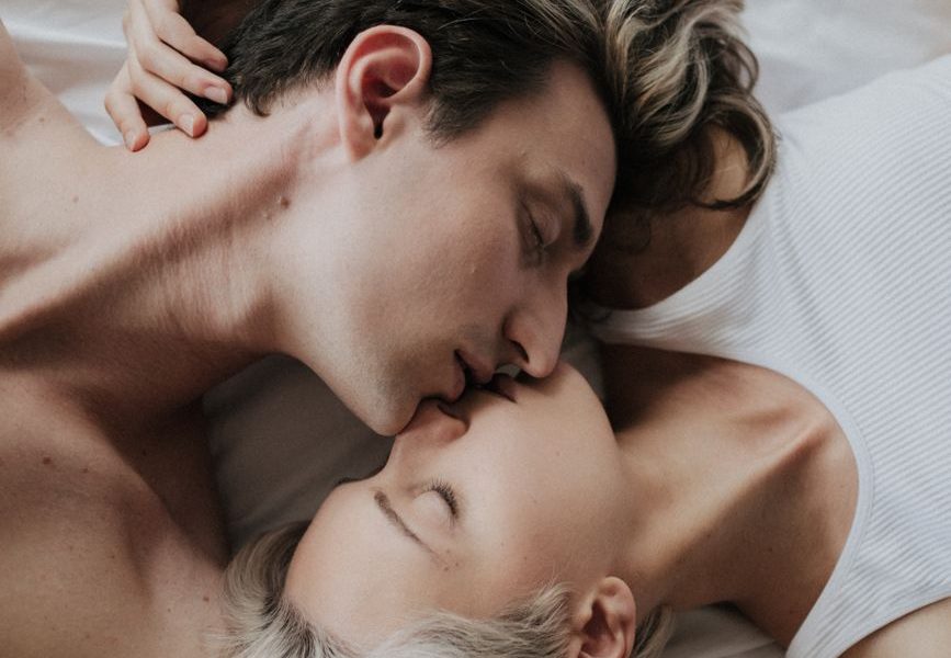 a romantic couple kissing on the bed